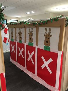 an office cubicle decorated for christmas with reindeers and x marks on the wall