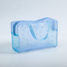 a clear bag with blue ribbon and snowflakes on the inside is sitting on a white surface