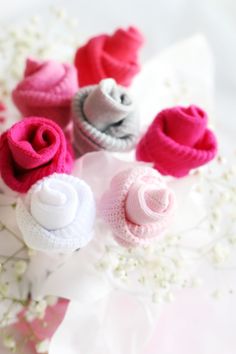 small knitted baby booties sitting on top of white flowers