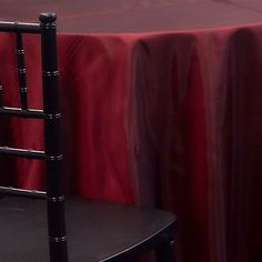 a black chair sitting next to a red table cloth