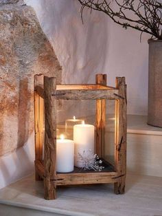 some candles are sitting on a shelf next to a stone wall