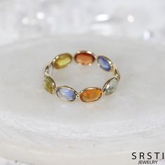 This handmade jewelry is meticulously crafted by skilled artisans in Jaipur. The sapphire used in this piece has high transparency and excellent quality, sparkling beautifully due to its cut. The design features an oval-cut fancy color sapphire wrapped in K18 gold, highlighting the softness of the gold in a simple yet elegant style. Stones are selected to match the ring size, so there may be slight variations in stone size, but they are generally of a similar size. As each piece is handmade, no two are exactly alike, and they may not be perfectly round. Since natural gemstones are used, you may notice color variations, cracks, or inclusions within the stone. We hope you will appreciate these as part of the natural charm of the gemstone. ☆ Materials ☆ Fancy Color Sapphire (approximately 6mm Oval Faceted Sapphire Ring Fine Jewelry, Elegant Oval Faceted Sapphire Ring, Oval Yellow Sapphire Ring In Yellow Gold, Luxury Oval Birthstone Gemstones, Faceted Sapphire Ring In Fine Jewelry Style, Multicolor Oval Sapphire Ring With Diamonds, Exquisite Oval Gemstones With Accents, Oval Yellow Sapphire Birthstone Jewelry, Round Yellow Sapphire Ring With Accent Stones