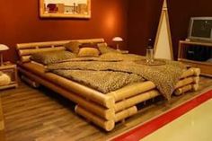 a bed made out of logs in a room with red walls and wooden flooring