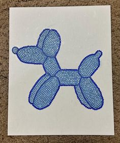 a blue dog shaped object on top of a white piece of paper