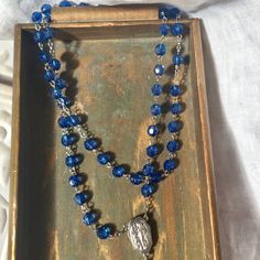 Beautiful blue colored vintage rosary . Acrylic medium Faceted beads and a silver detailed crucifix ,and a Lourdes Holy Water medallion centerpiece and links. Rosary is in perfect condition! Beautiful for a decor piece. The colors are beautiful! Nice for making a Altered Necklace... 22 inch drop...so total length is 44 inches Blue Crucifix Necklace For Spiritual Wear, Blue Crucifix Necklace For Spiritual Purposes, Blue Rosary With 8mm Beads And Crucifix, Blue Rosary With 8mm Beads In Cross Shape, Rosary With Faceted Beads And Crucifix, Handmade Blue Rosary For Jewelry Making, Adjustable Blue Rosary With Miraculous Medal, Handmade Blue Rosary With Cross Shape, Handmade Blue Rosary With Cross