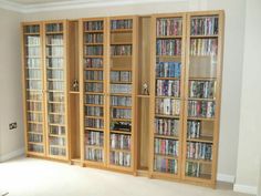 a room filled with lots of wooden bookshelves next to a wall full of movies