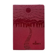 a red notebook with the words money written on it and mountains in the back ground