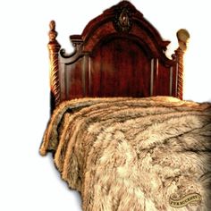 the bed is made with fur and wooden headboard