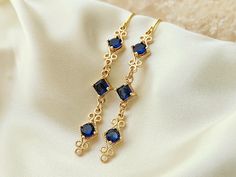 These elegant blue and gold earrings, are perfect for your special occasion! They feature sapphire blue zircon gemstones, in a high quality, 18k gold plated setting.  Product details: * 18k gold plated ear wires; Lead and nickle free * Zircon gemstones * 18k gold plated setting * Handmade, with lots of love and care! - Length:    2 inches - Width:     .25 inches ❤ You can click here to see more unique jewelry from Flutterbird: https://www.etsy.com/shop/FlutterbirdCo My goal is to provide every c Sapphire Crystal Dangle Earrings For Formal Occasions, Sapphire Dangle Crystal Earrings For Formal Occasions, Sapphire Crystal Dangle Earrings For Formal Events, Elegant Sapphire Crystal Dangle Earrings, Elegant Blue Crystal Earrings, Gold Sapphire Dangle Earrings, Gold Sapphire Drop Earrings, Sapphire Drop Crystal Earrings, Elegant Sapphire Crystal Earrings For Pierced Ears