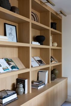 a book shelf with books and vases on it