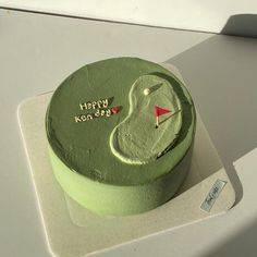 a green birthday cake with a golf motif on it's side and the words happy koon day written in gold