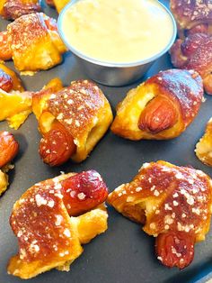 mini pretzel dogs with beer cheese are on a plate next to a bowl of dip