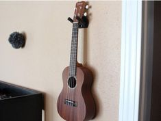 a wooden ukulele hanging on the wall