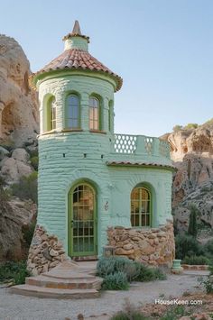 a building made out of rocks and stone with a small balcony on the top floor