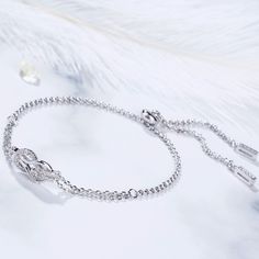 A brilliant way to show her your love is forever, this dainty bracelet will certainly touch her heart. This meaningful design showcases two ribbons interlocked for a infinity symbol-shaped look, while shimmering round stones add eye-catching sparkle to the design. This elegant bracelet makes a stunning statement of everlasting love. A great anytime choice, this fashion bracelet is sure to become an instant favorite. Carat Weight: 0.21 ctStone Size: 1.1 mmNumber of Stones: 21 Stone Shape: RoundSt Silver Infinity Bracelets With Diamond Accents, Elegant Infinity Cubic Zirconia Jewelry, Elegant Promise Jewelry With Adjustable Chain, Elegant Infinity Bracelets With Diamond Accents, Elegant Infinity Bracelet With Diamond Accents, Anniversary Infinity Bracelet In Cubic Zirconia, Infinity Bracelet With Diamond Accents For Gift, Infinity Bracelet With Diamond Accents As Gift, Elegant Diamond Bracelets For Promise