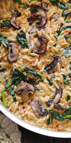 pasta with mushrooms and spinach in a white dish