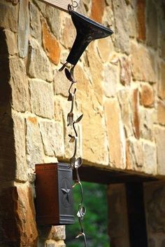 a clock hanging from the side of a stone building