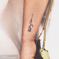 a woman's arm with a flower tattoo on it