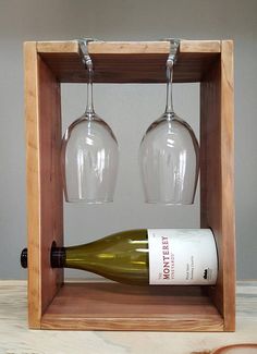 two wine glasses and a bottle in a wooden box