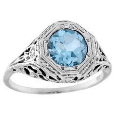 The ring has a vintage aesthetic, add a touch of classic to the ring with a delicate filigree setting. Slender threads of gold weave and swirl, forming a mesmerizing web of tiny scrolls and flourishes. The effect is both delicate and luxurious, like a whisper of old-world elegance adorning your finger. The rich, sparkling blue topaz is faceted in a round cut, in a slightly softer and more muted color of white gold setting make the ring both eye-catching and luxurious yet delicate. CHARACTERISTIC White Gold Set, Topaz Color, Filigree Ring, Vintage Aesthetic, Muted Colors, Ring Box, White Gold Rings, Solitaire Ring, Vintage Stil