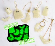 glow in the dark ghost earrings and necklaces on a white table with green lettering