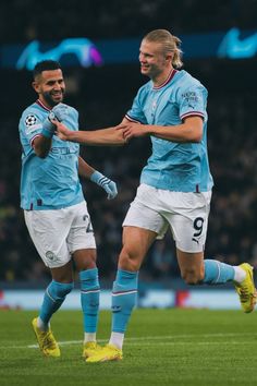 two soccer players are congratulating each other on the field