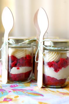 two jars filled with red, white and blue desserts sitting on top of a table