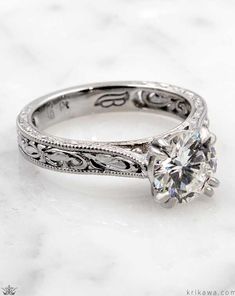 an antique style diamond engagement ring with filigrees