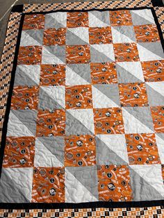 an orange and white quilt on the ground