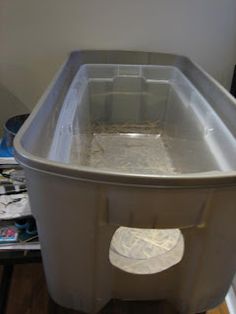 a large plastic container sitting on top of a wooden floor