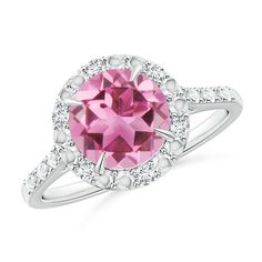 This classic engagement ring showcases a vivid pink tourmaline in a claw setting. Round diamonds alternated with beading details form a halo around this striking round gem and adorn the shoulders. The cutwork on the gallery elevates the beauty of this 14k white gold pink tourmaline ring. Classic Pink Halo Ring, Pink Round Halo Ring, Pink Round Cut Halo Ring With Center Stone, Pink Halo Ring With Round Setting, Pink Halo Ring With Center Stone And Round Cut, Pink Halo Ring With Center Stone In Round Cut, Pink Halo Ring With Accent Stones, Pink Round Halo Ring With Accent Stones, Classic Pink Halo Ring With Gemstone