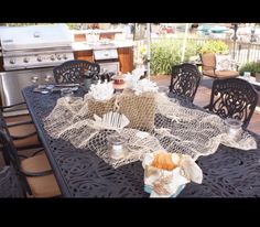 an outdoor table covered with doily and other items on it's patio area