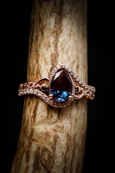 a ring that is sitting on top of a piece of wood with a blue stone in it