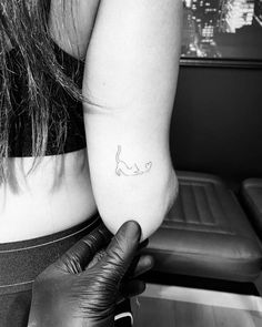 a woman's arm with a small tattoo on the left side of her arm