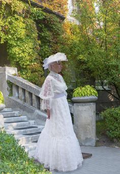 Made up in delicate Chantilly lace, this Edwardian-inspired dress has a crepe underlining. The bodice offers a relaxed fit with a scooped neckline in the crepe, allowing a peek through the lace which has a high neckline - the perfect spot for your favorite pin or brooch. Poufed lace sleeves are caught into a cuff just below the elbow, and continue with a deep lace ruffle below the band. The comfy elastic waist is covered by a belt in matching crepe. The full skirt features a generous lace overla White Victorian Dress For Garden Party, Elegant Lace Dress With Scalloped Lace For Daywear, Elegant Lace Dress With Scalloped Detail For Daywear, Elegant Victorian Lace Dress For Garden Party, Elegant Lace Victorian Dress For Garden Party, Lace Dress With Lace Sleeves For Garden Party, Victorian Lace Trim Dress For Garden Party, Lace Victorian Dress With Fitted Bodice, Elegant Victorian Dress For Summer Garden Party