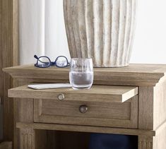 a wooden table with a vase and glasses on it