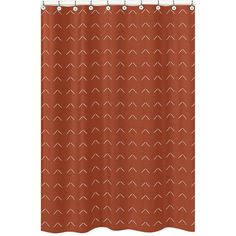 an orange shower curtain with white arrows on it, and a brown background that looks like the