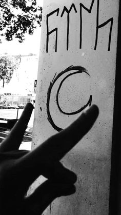 a hand is pointing at a sign with the word fima written on it in black and white