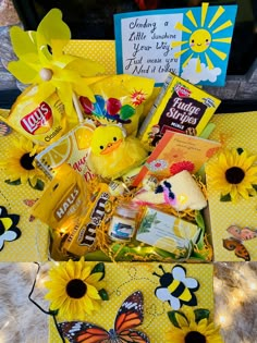 a yellow box filled with lots of treats and candy sitting on top of a table