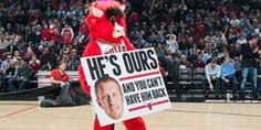 a person in a red devil costume holding a sign