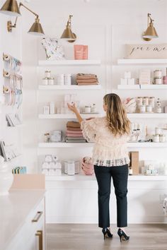 a woman standing in front of a store display with the words xo and maine boutique branding session