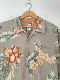 "-Description- >men's brown floral hawaiian shirt >button front >collared >open pocket on the front >size XXL >great hawaiian! >condition: good >color(s): brown, orange, green >fabric(s): 100 silk >brand: jamaica jaxx >care: machine wash -Measurements- >size: XXL ✩ all measurements are taken with the item laying flat & some sizes are estimates so please check measurements ✩ chest: 50\" / 127cm length: 30 \" / 76cm shoulder to sleeve end: 11.5\" / 29cm shou Hawaiian Collared Camp Shirt With Floral Print, Hawaiian Floral Print Collared Camp Shirt, Tropical Collared Hawaiian Shirt With Floral Print, Hawaiian Hibiscus Print Button-up Shirt, Brown Camp Shirt With Camp Collar For Vacation, Brown Short Sleeve Hawaiian Shirt, Brown Hawaiian Summer Tops, Floral Hawaiian Shirt, Green Leaf Print