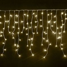 there is a string of lights that are on the side of a wall in the dark