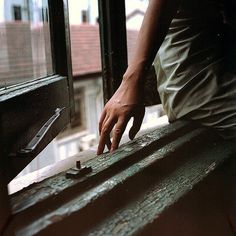 a person reaching for something in front of a window