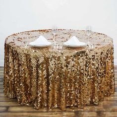 the table is covered with gold sequins and place settings for two people to sit at