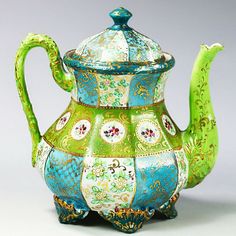 an ornately painted teapot with a lid on it's side is shown