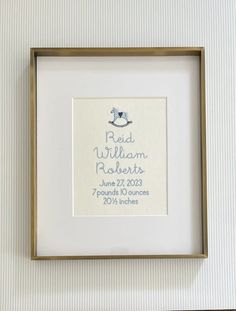 a baby's birth announcement is framed in a gold frame with a white background