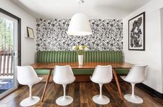 a dining room table with four chairs and a bench in front of a window that looks out onto the outdoors