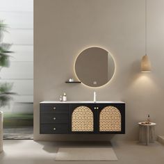 a bathroom with a round mirror above the sink and a black cabinet below it,