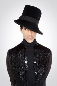 a woman wearing a black top hat with sequins on her jacket and turtle neck